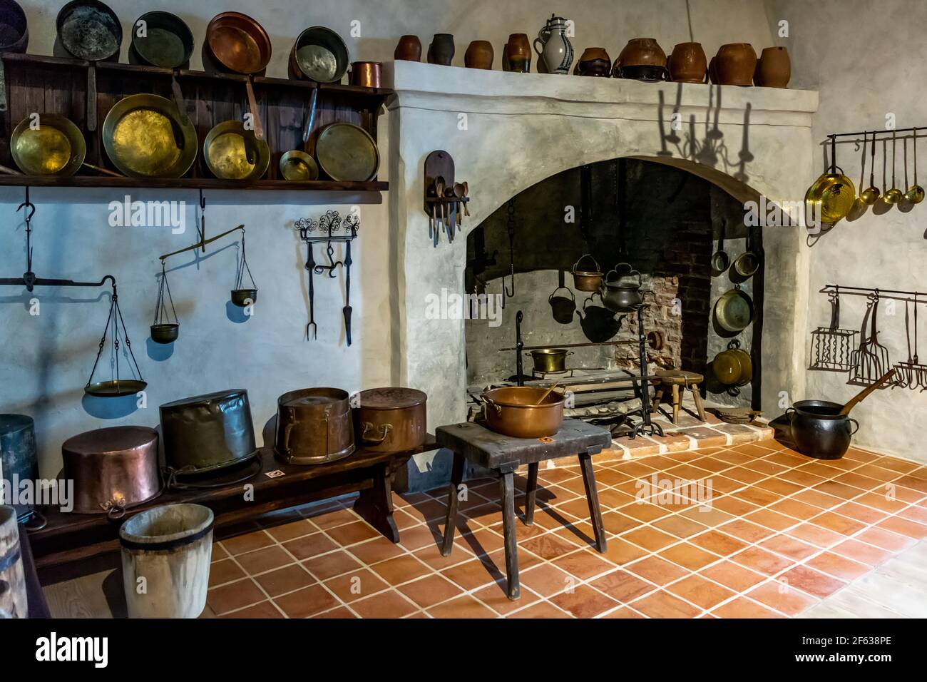 Interiores del Castillo de Bauska - cocina con latón del siglo 16th-17th, hierro y equipos de cocina de madera Foto de stock