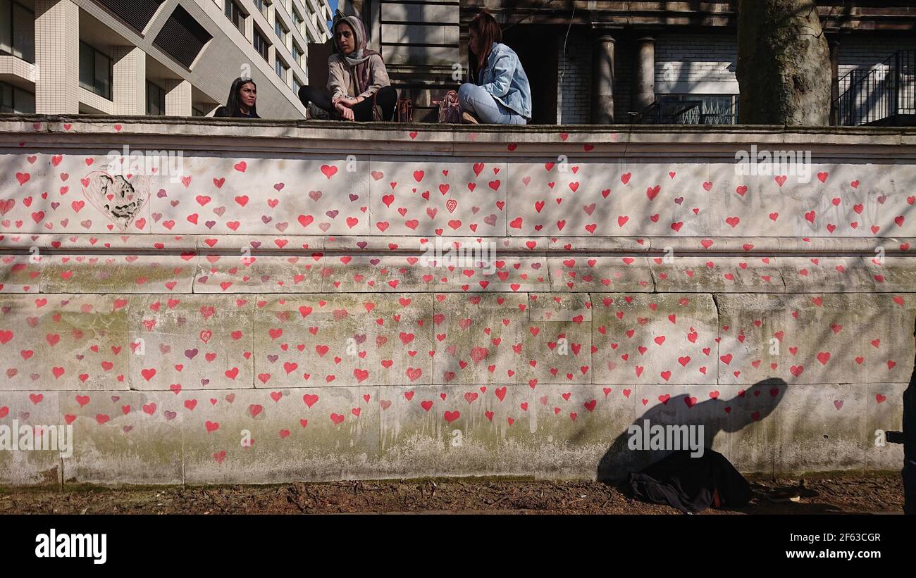Londres, Reino Unido. 29th de marzo de 2021. Keir Starmer visita a familiares y amigos desconsolados mientras pintan corazones en la pared Conmemorativa de Covid. Foto de stock