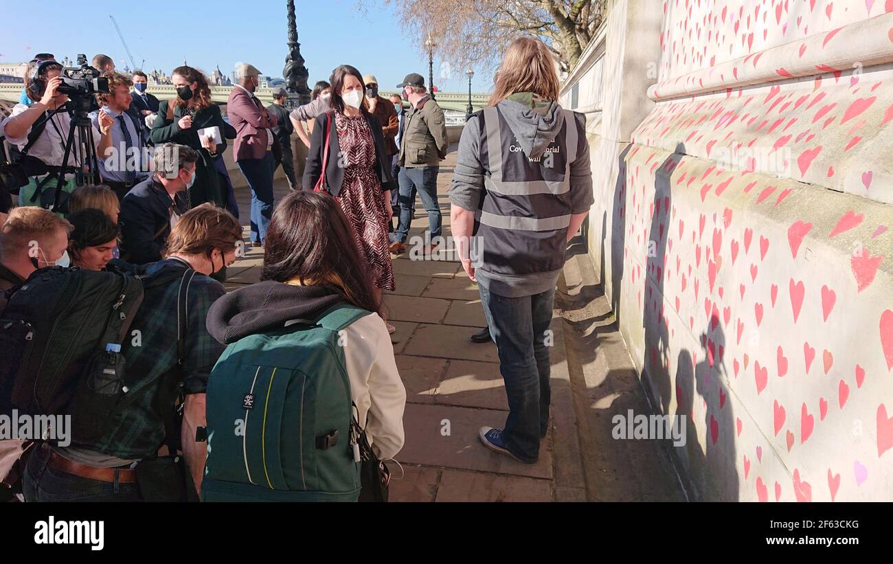 Londres, Reino Unido. 29th de marzo de 2021. Keir Starmer visita a familiares y amigos desconsolados mientras pintan corazones en la pared Conmemorativa de Covid. Foto de stock