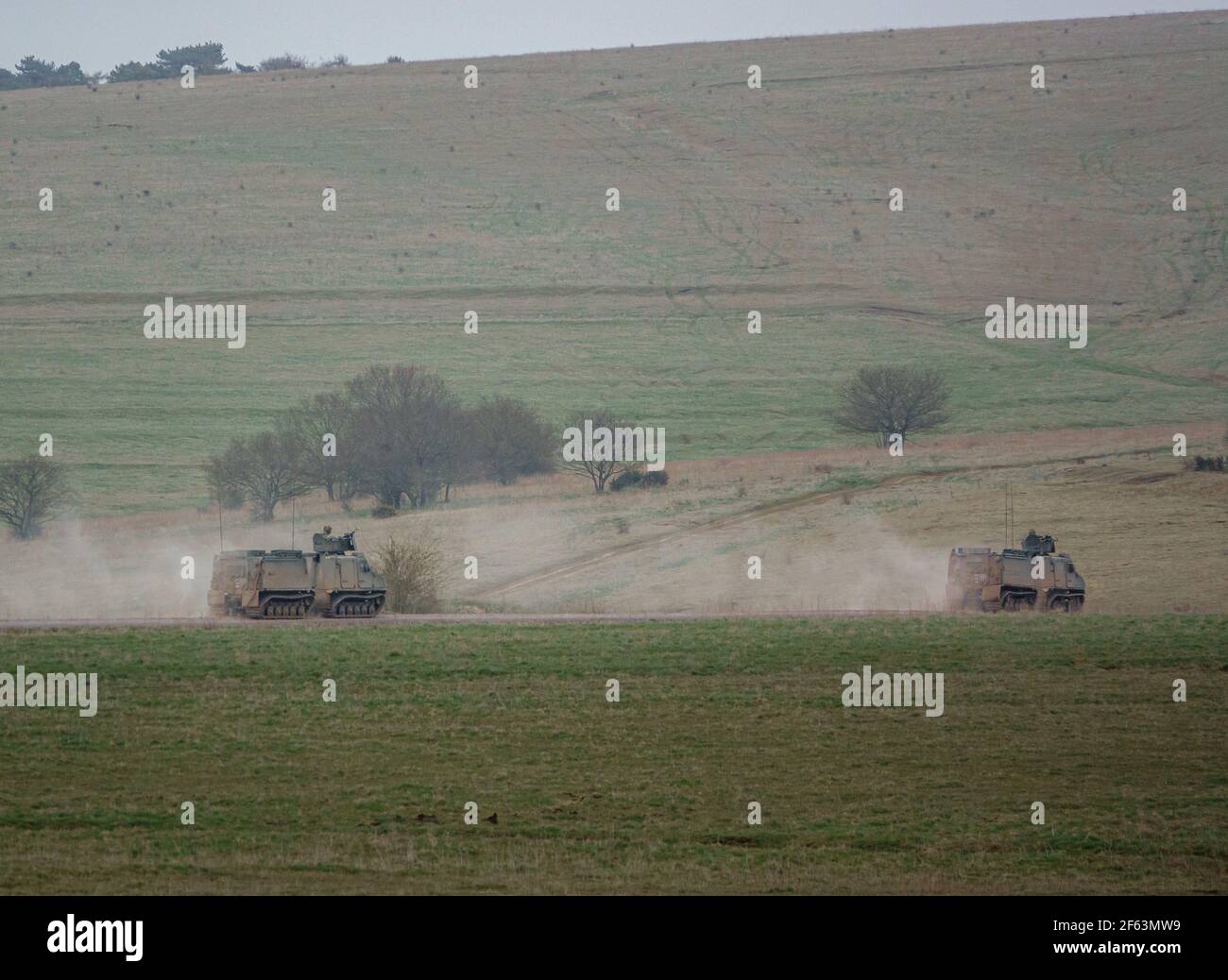Ejército Británico BvS10 Vehículo blindado todo terreno Viking que se lanza a lo largo de una pista de piedra polvorienta en el ejercicio, Salisbury Plain UK Foto de stock