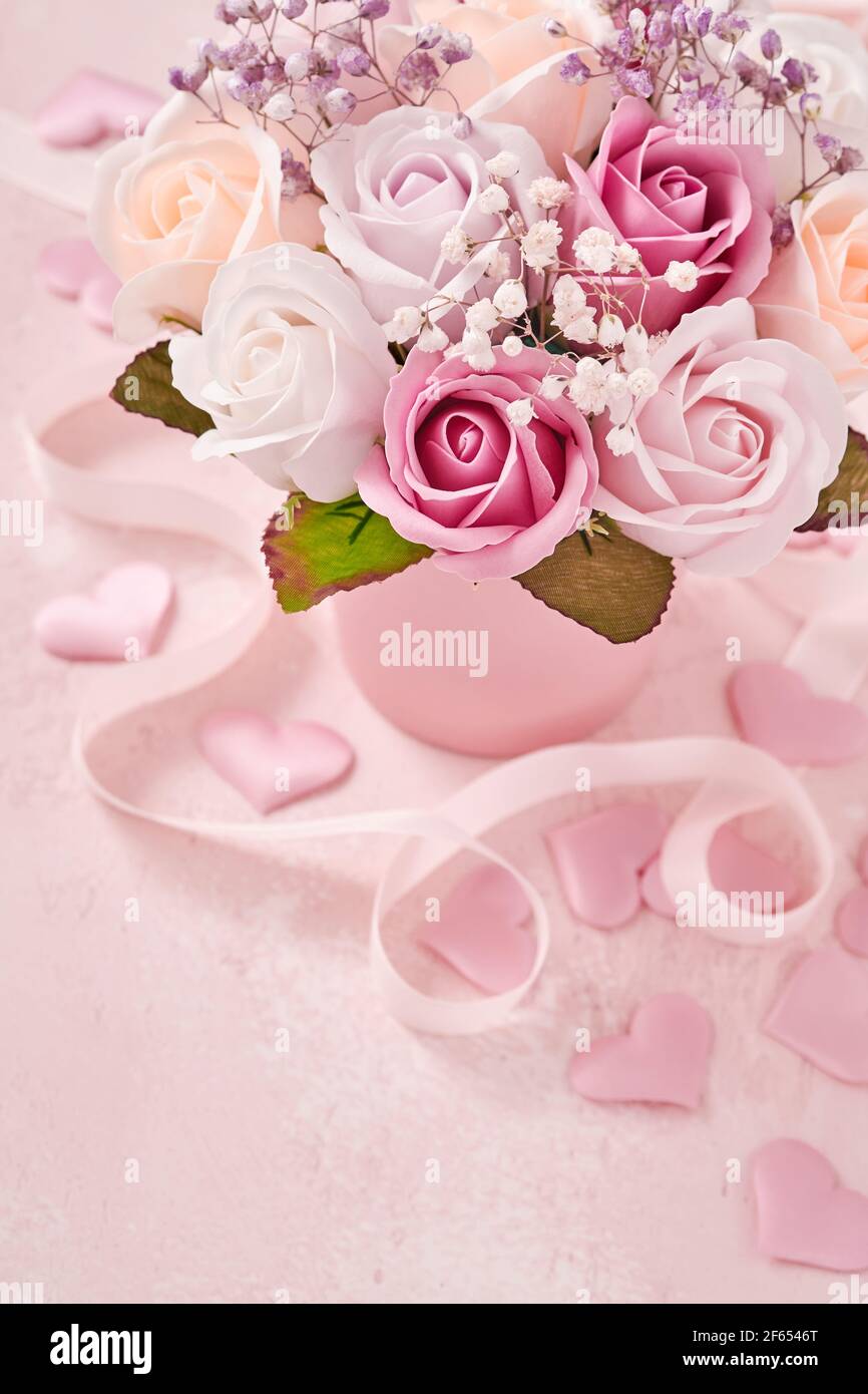 Composición festiva con hermosas rosas delicadas flores en caja redonda  rosa sobre fondo rosa claro. Tarjeta de felicitación para el día de las  madres felices. Plano, copia Fotografía de stock - Alamy