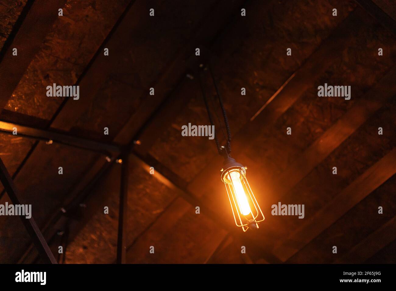 lámparas edison bajo el techo. iluminación decorativa a la antigua usanza bajo el techo de la veranda de una casa de vacaciones de campo Foto de stock