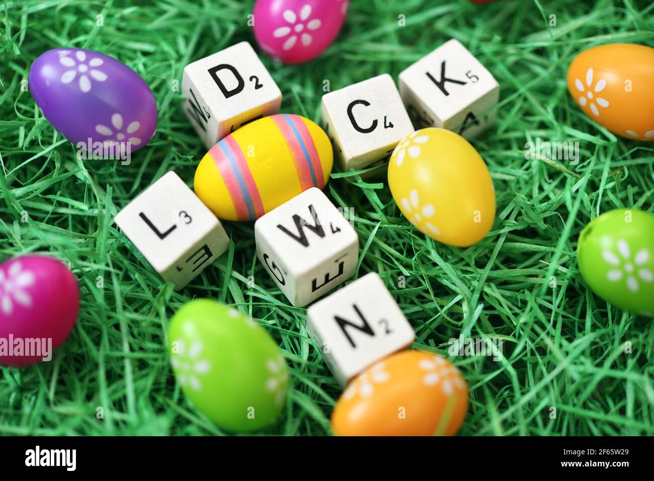 Cubos de la letra y huevo de Pascua que forman la palabra Lockdown Foto de stock
