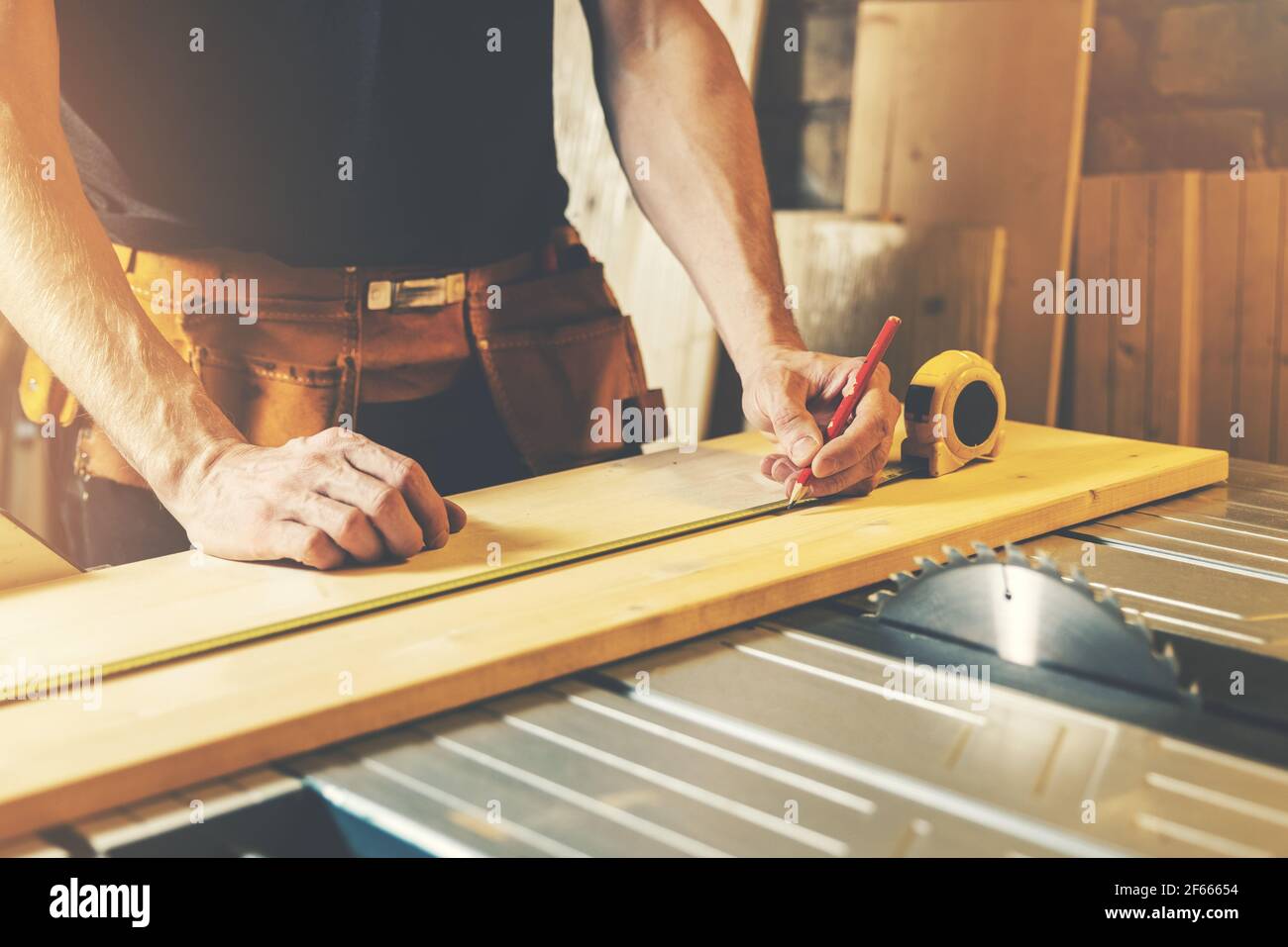 taller de carpintería - carpintero medir y marcar la tabla de madera para cortar Foto de stock
