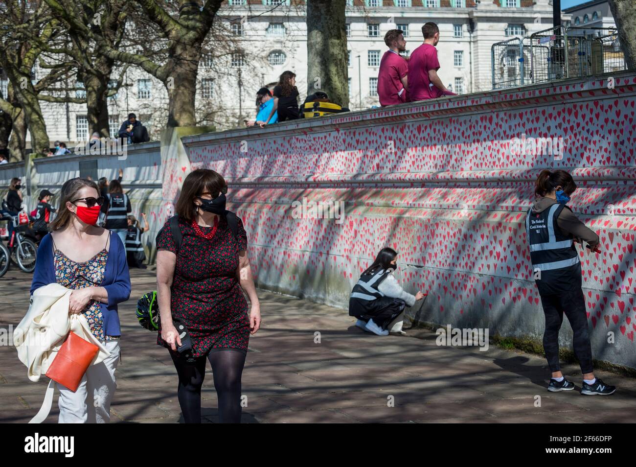 Londres, Reino Unido. 30th de marzo de 2021. La gente pasa corazones en una pared en Lambeth junto al río Támesis, y cada corazón representa a alguien que murió durante la actual pandemia del coronavirus en el Reino Unido. Llamado el Muro Conmemorativo Nacional de Covid, ha sido creado por las familias de duelo por la Justicia de Covid-19 y se extenderá por media milla cuando se complete. Crédito: Stephen Chung/Alamy Live News Foto de stock