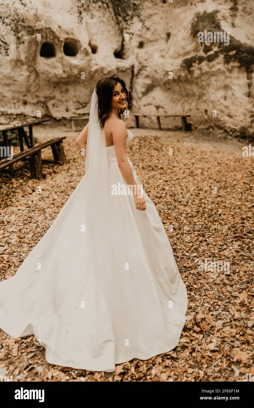mujer joven novia en blanco vestido de boda con velo largo correr