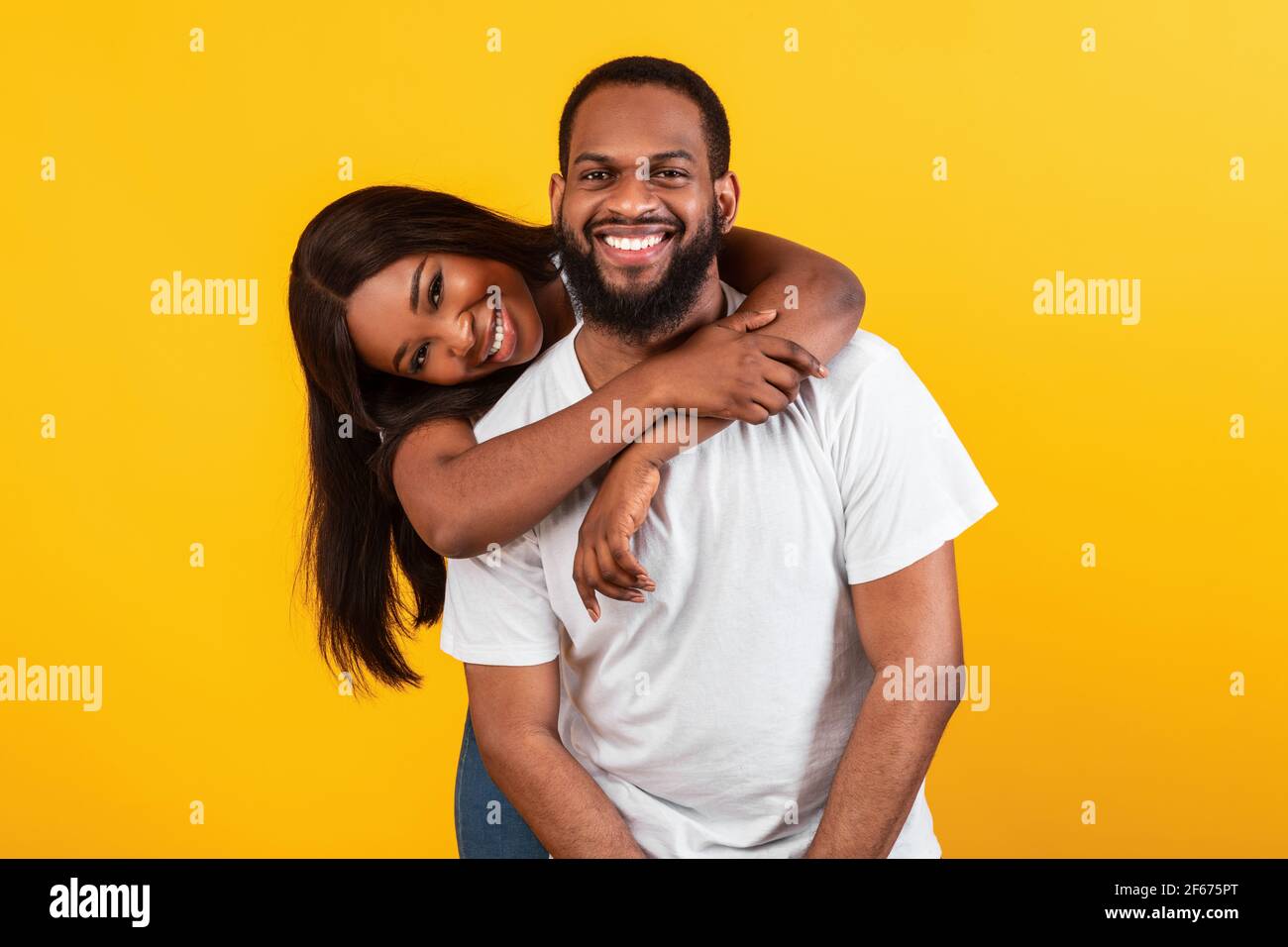 Mujer afroamericana abrazando a su hombre desde la espalda Foto de stock