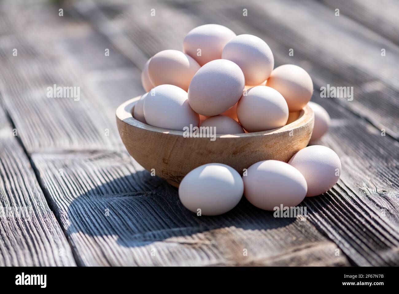 Huevos de pollo orgánicos en plato de madera Foto de stock