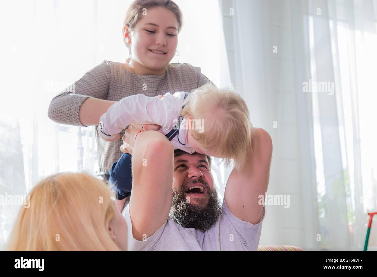 Papa E Hija Juegan Con El Bebe Sujetandolo En La Cabeza Dia Festivo De La Madre Fotografia De Stock Alamy