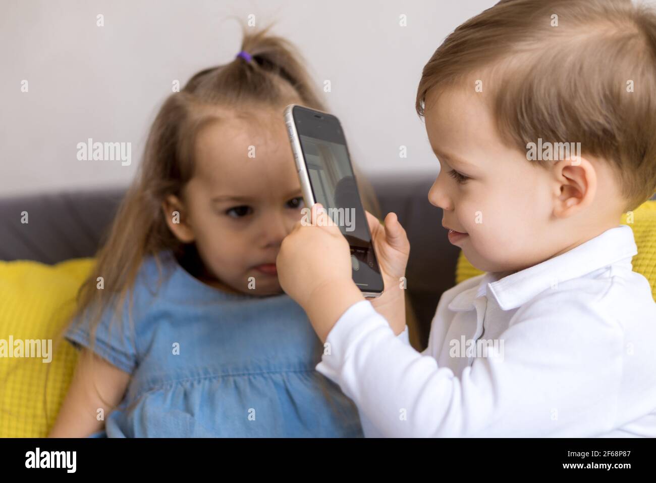 Felices Y Tristes Hermanos Pequenos Y Lindos Del Preescolar Hermano Del Bebe Y Hermana Del Nino Hablan Video Conferencia En El Sofa Gris Amarillo Las Fotografias Del Nino Triste Disgustaron Fotografia De