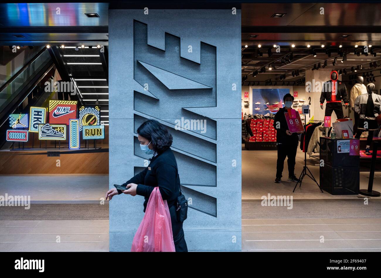 Un peatón pasa por delante de la Marca multinacional estadounidense de ropa  deportiva, la tienda Nike y su logotipo visto en Hong Kong Fotografía de  stock - Alamy
