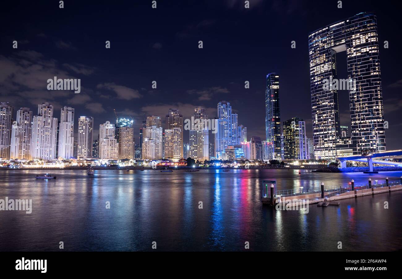Vista panorámica de los raspadores iluminados del cielo y las residencias en el puerto deportivo de dubai capturados desde el Ain Dubai en las islas de aguas azules, Dubai, EAU. Foto de stock