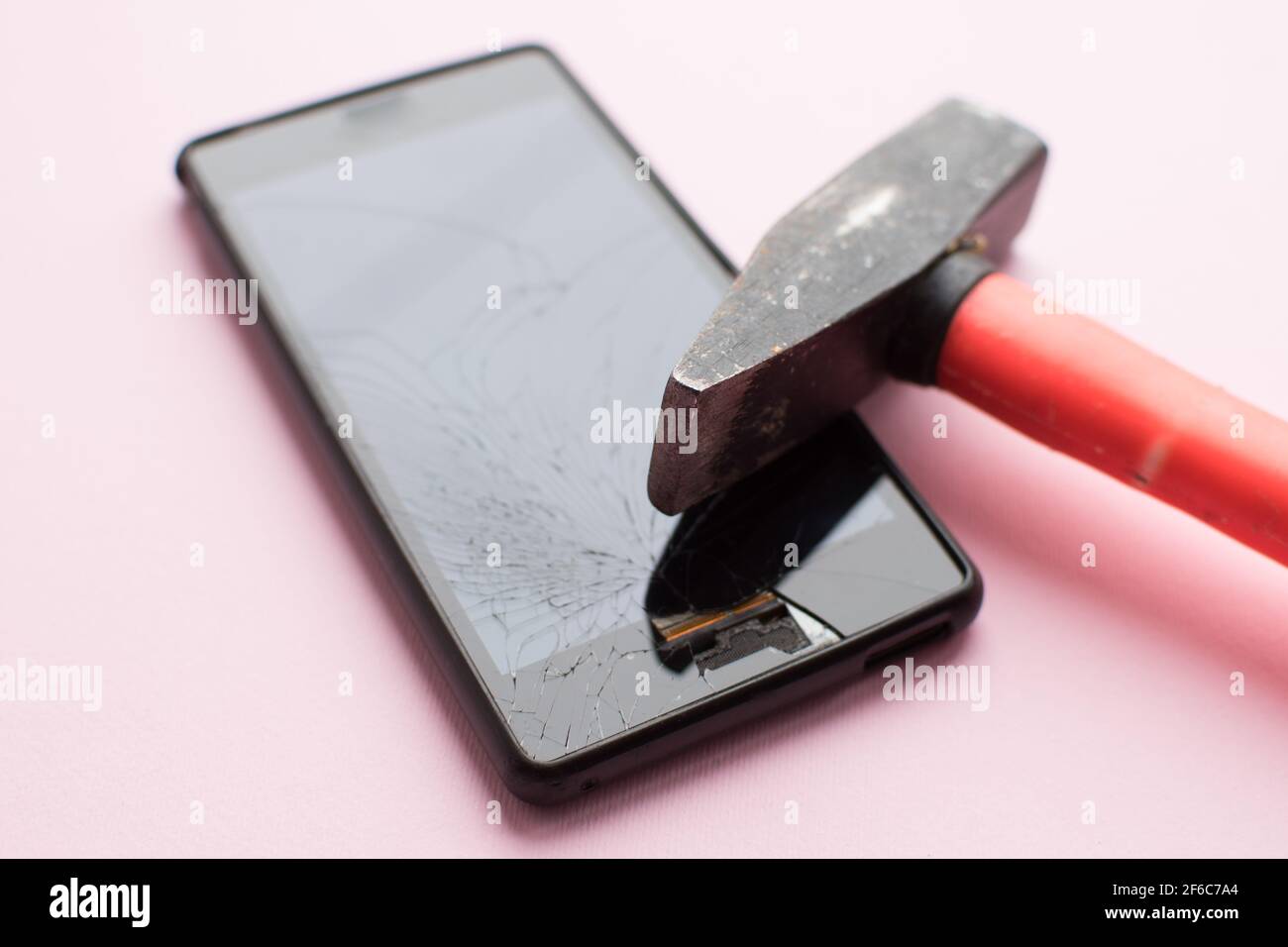 Martillo y teléfono móvil con pantalla rota sobre fondo rosa. Concepto de  smartphone averiado Fotografía de stock - Alamy
