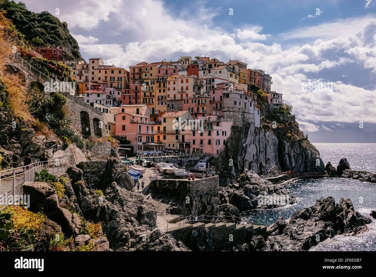 Vista clásica de Manarola, Cinque Terre, Italia - Colorful Houses en una formación de roca de acantilado espectacular cerca del mar con un puerto natural de pesca Foto de stock