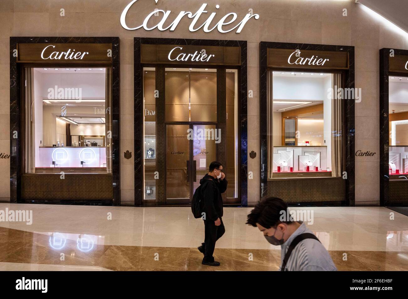 Hong Kong, China. 25th de marzo de 2021. Los compradores pasan por el  conglomerado francés de productos de lujo Cartier tienda en Hong Kong.  Crédito: Budrul Chukrut/SOPA Images/ZUMA Wire/Alamy Live News Fotografía