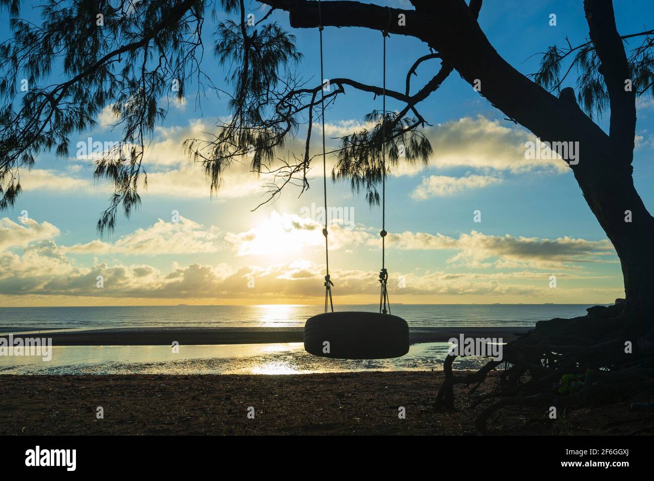 Silueta de un columpio al amanecer, Carmila Beach, cerca de Sarina, Queensland, Queensland, Australia Foto de stock