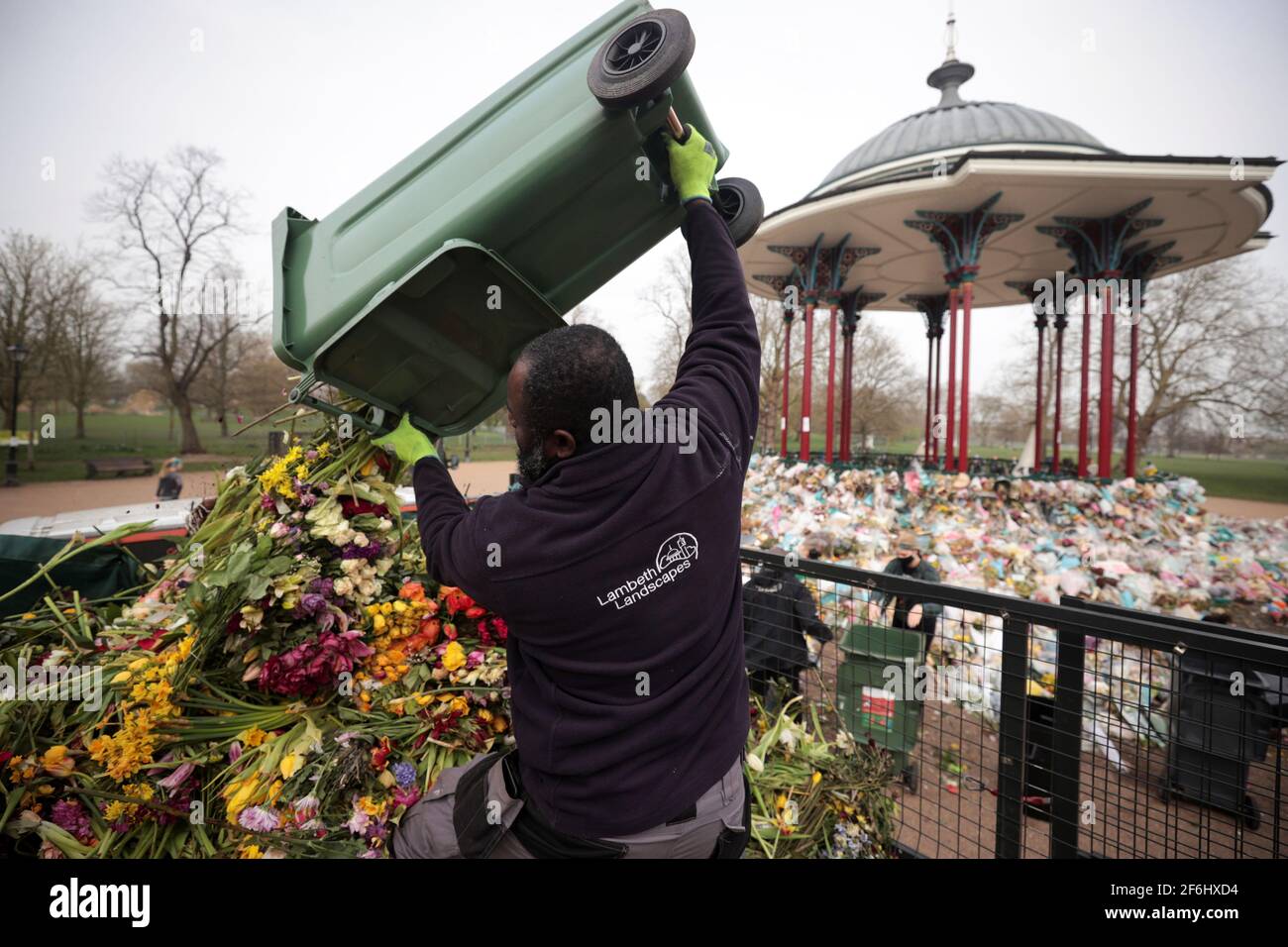 Un trabajador del consejo limpia tributos florales de un monumento improvisado para la asesinada Sarah Everard del Bandstand común de Clapham en Londres, Gran Bretaña, el 1 de abril de 2021. REUTERS/Hannah McKay Foto de stock