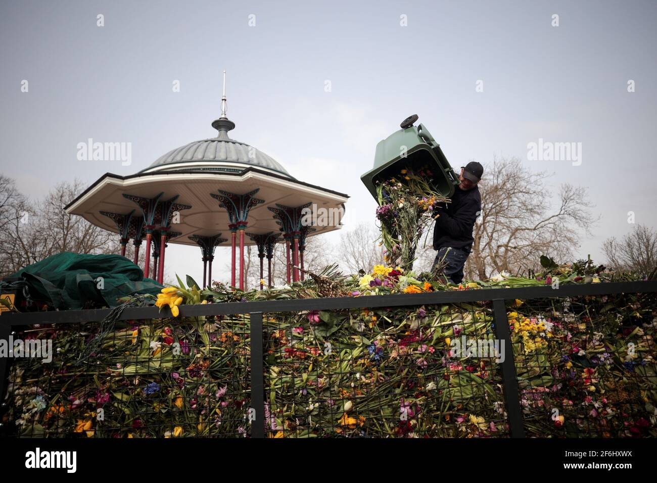 Un trabajador del consejo limpia tributos florales de un monumento improvisado para la asesinada Sarah Everard del Bandstand común de Clapham en Londres, Gran Bretaña, el 1 de abril de 2021. REUTERS/Hannah McKay Foto de stock