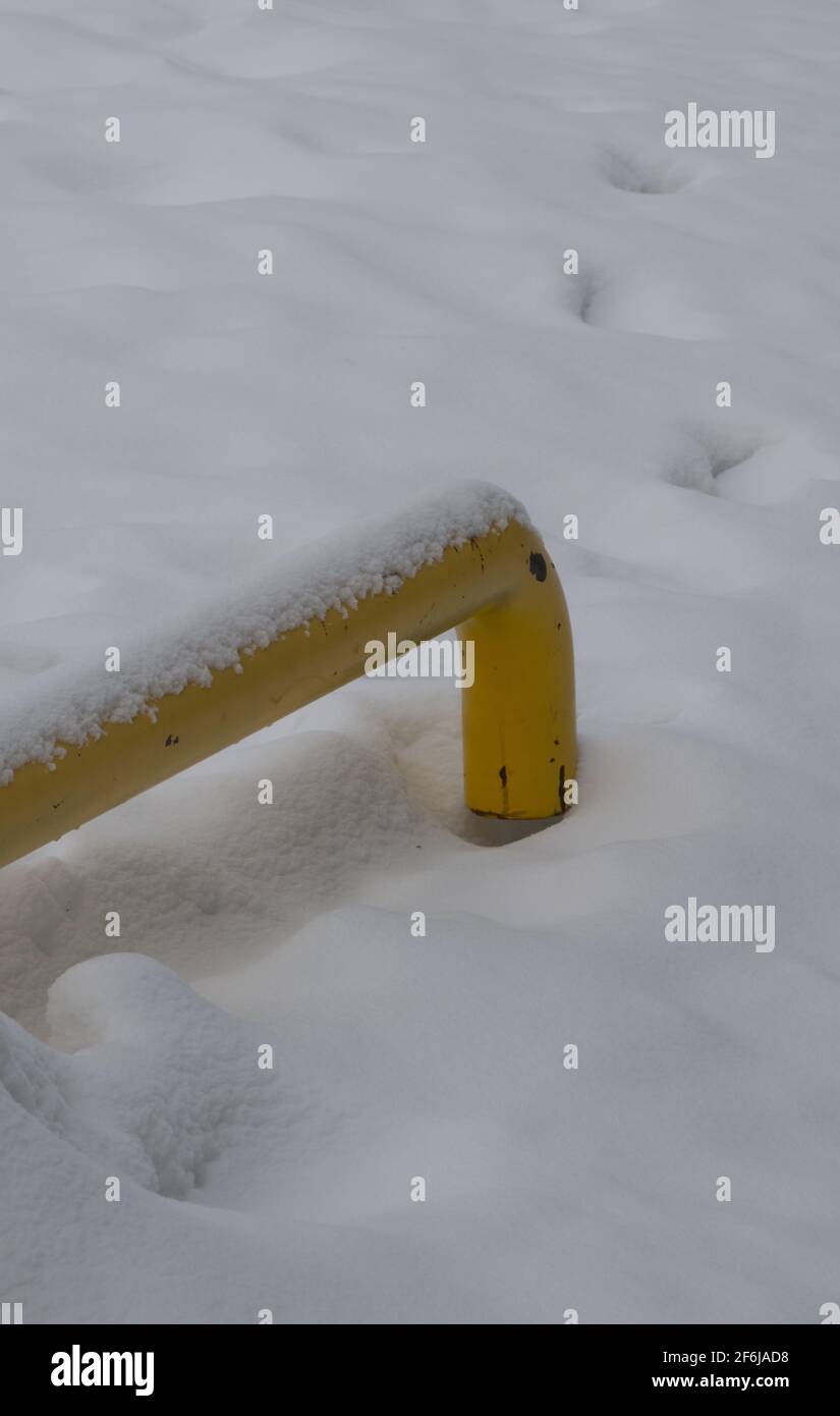 tubo amarillo en la nieve profunda con nieve fresca en la parte superior vertical fondo de invierno o fondo de pantalla con espacio blanco vacío para el tipo o logotipo grungy look Foto de stock