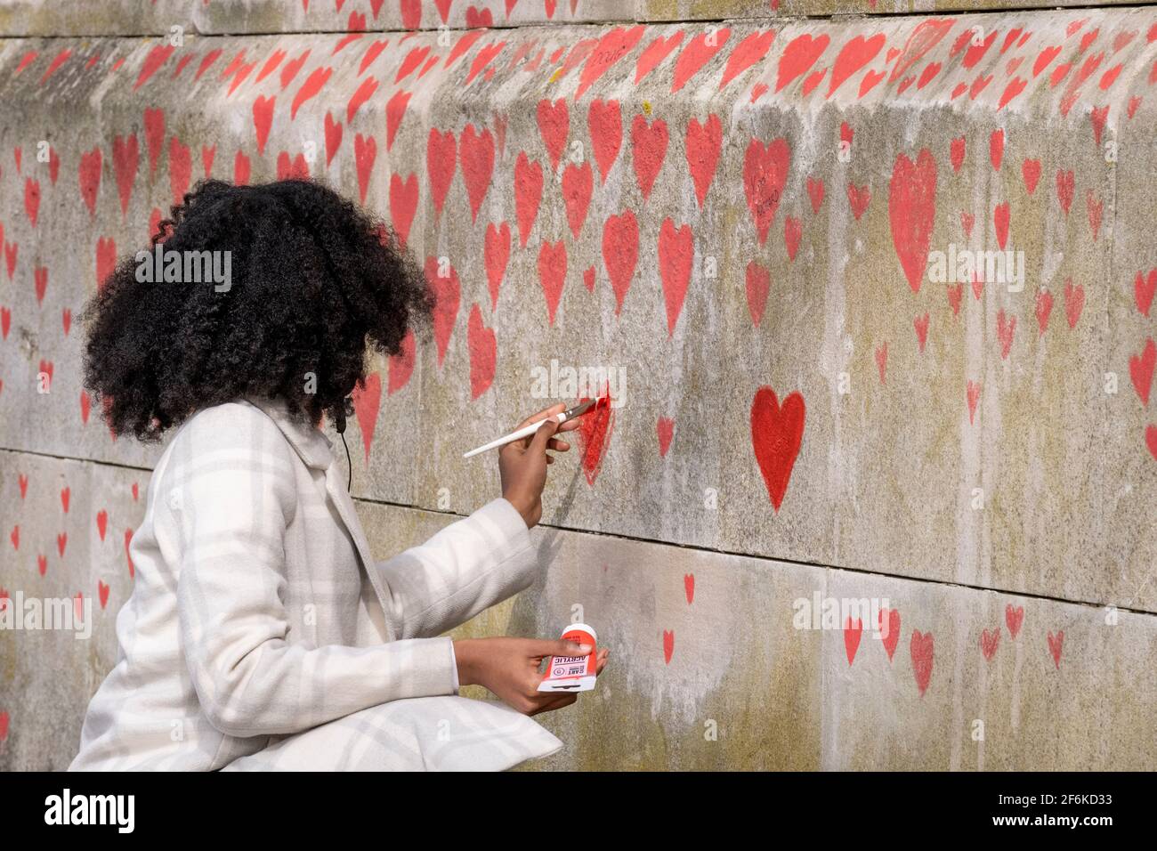 Corazones rojos que forman el Muro Conmemorativo Nacional Covid, un homenaje a las más de 150.000 víctimas británicas de la pandemia del Coronavirus el 1st de abril de 2021, en Londres, Reino Unido. Familiares y amigos de las víctimas de Covid-19 han comenzado a trabajar en la pared situada en las afueras del Hospital de St Thomas. Foto de stock