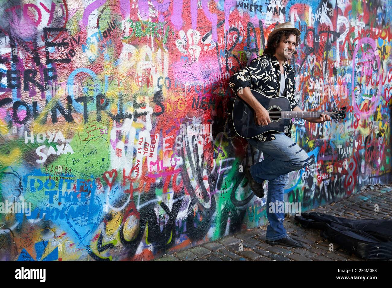 Praga, República Checa, 17 de septiembre de 2018. El músico de calle toca la guitarra de John Lennon Wall en Praga, un lugar turístico popular. Foto de stock