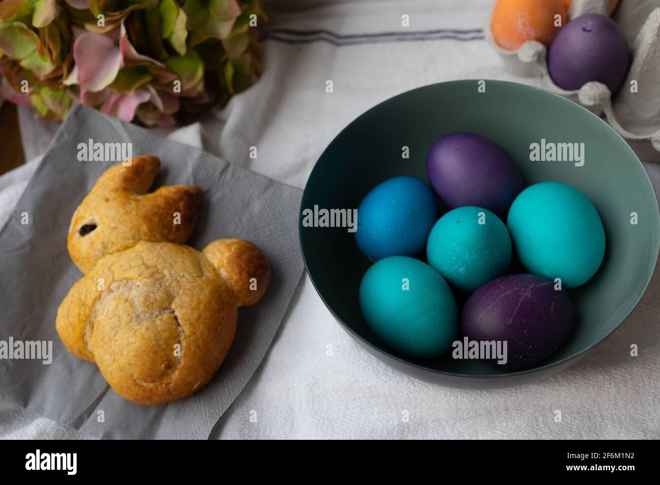 Huevos de Pascua en un tazón de fuente azul, turquesa, púrpura y naranja. Foto de stock