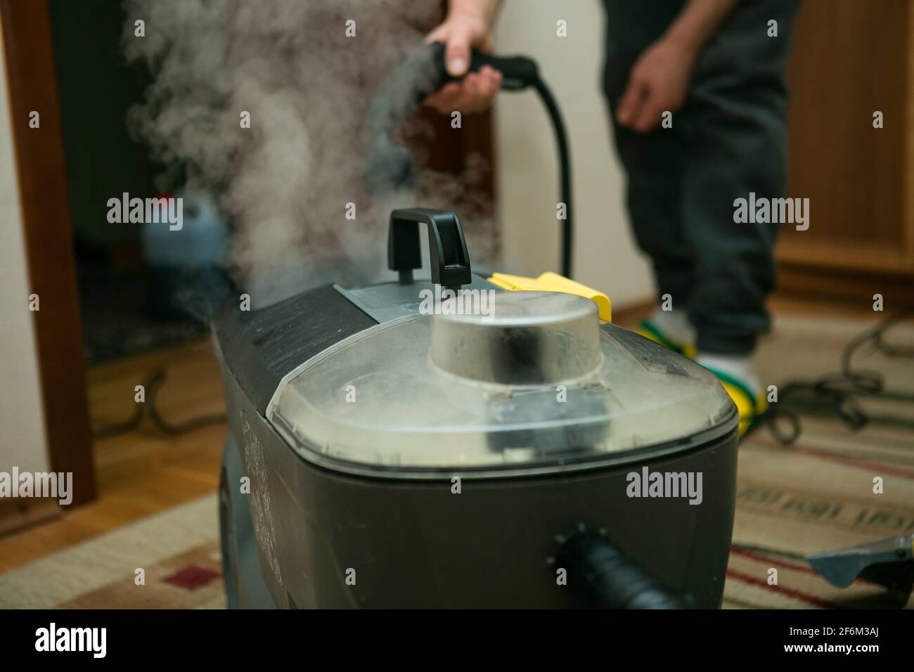 El proceso de limpieza de alfombras con una aspiradora de vapor. Un  empleado de una empresa de limpieza limpia la alfombra con vapor Fotografía  de stock - Alamy