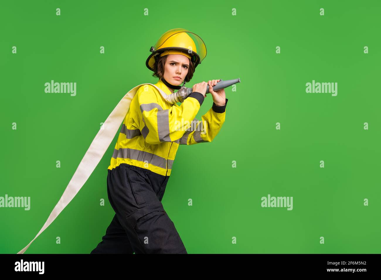 Preguntarse Lujo Parecer Foto de la mujer joven y furiosa segura ropa de trabajo casco amarillo  sostener manguera de agua aislada fondo de color verde Fotografía de stock  - Alamy