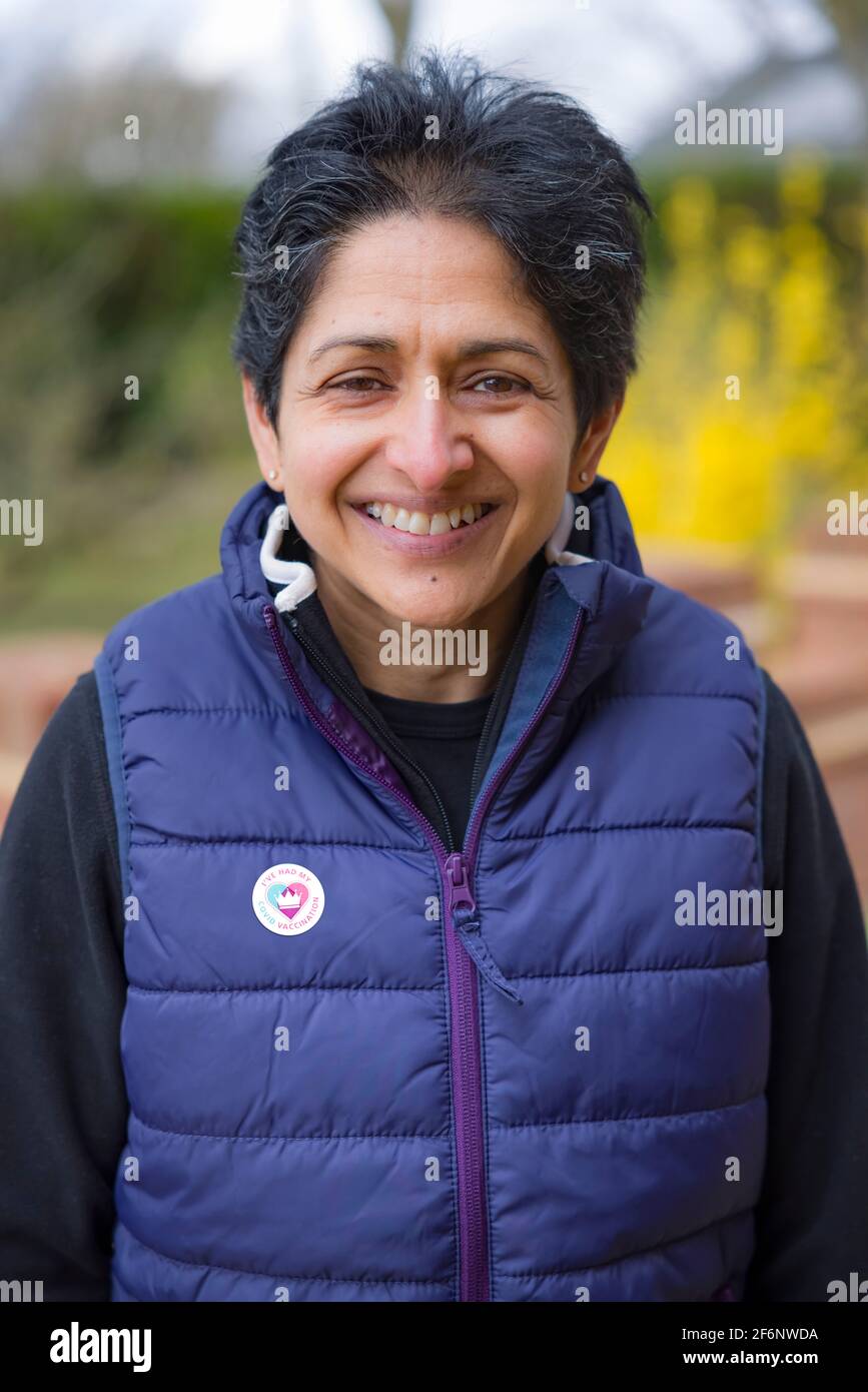 BUCKINGHAM, Reino Unido - 25 de marzo de 2021. Mujer étnica India con una pegatina de vacunación COVID-19 en Inglaterra. Campaña de vacunación en el Reino Unido. Foto de stock