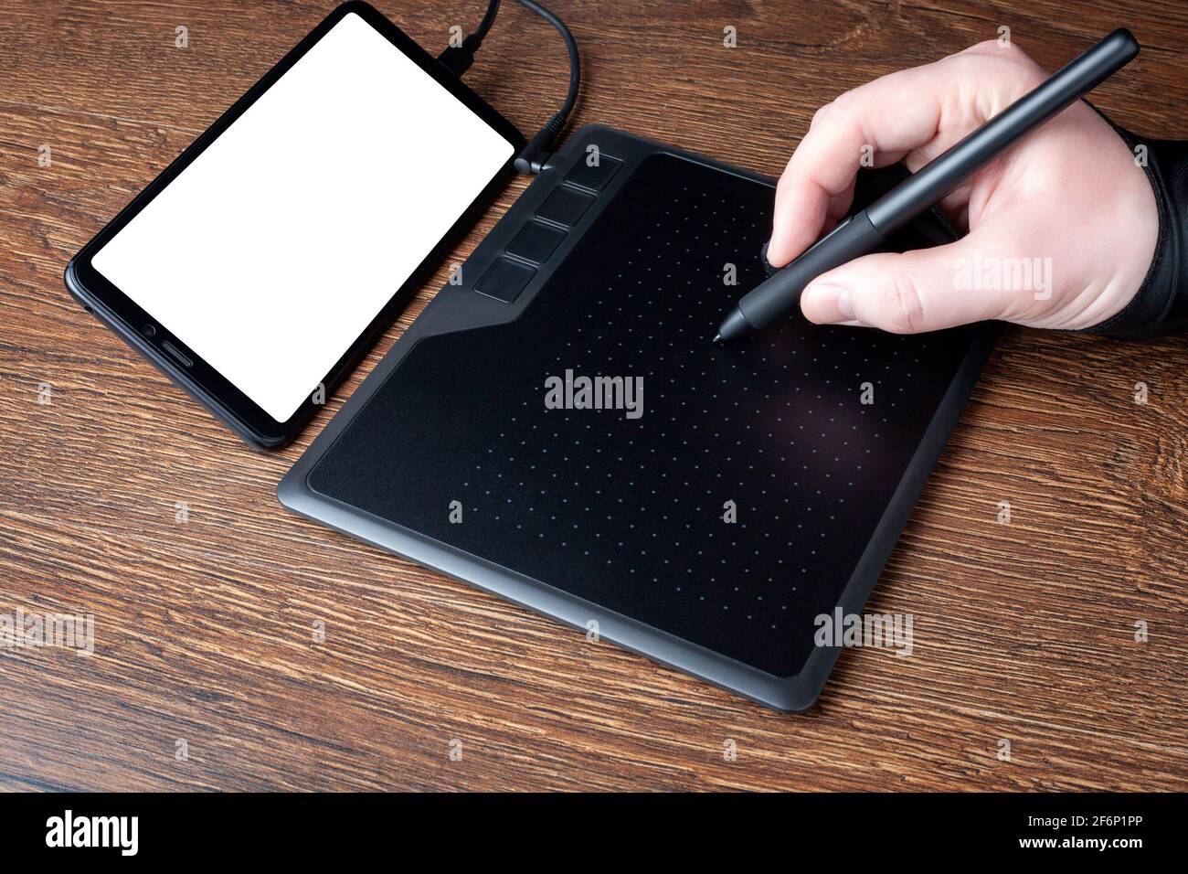 Diseñador profesional que utiliza una tableta gráfica conectada a un  smartphone con un lápiz digital. Para volver a tocar la foto. Dibujo por  ordenador con lápiz óptico. Haciendo mod Fotografía de stock -