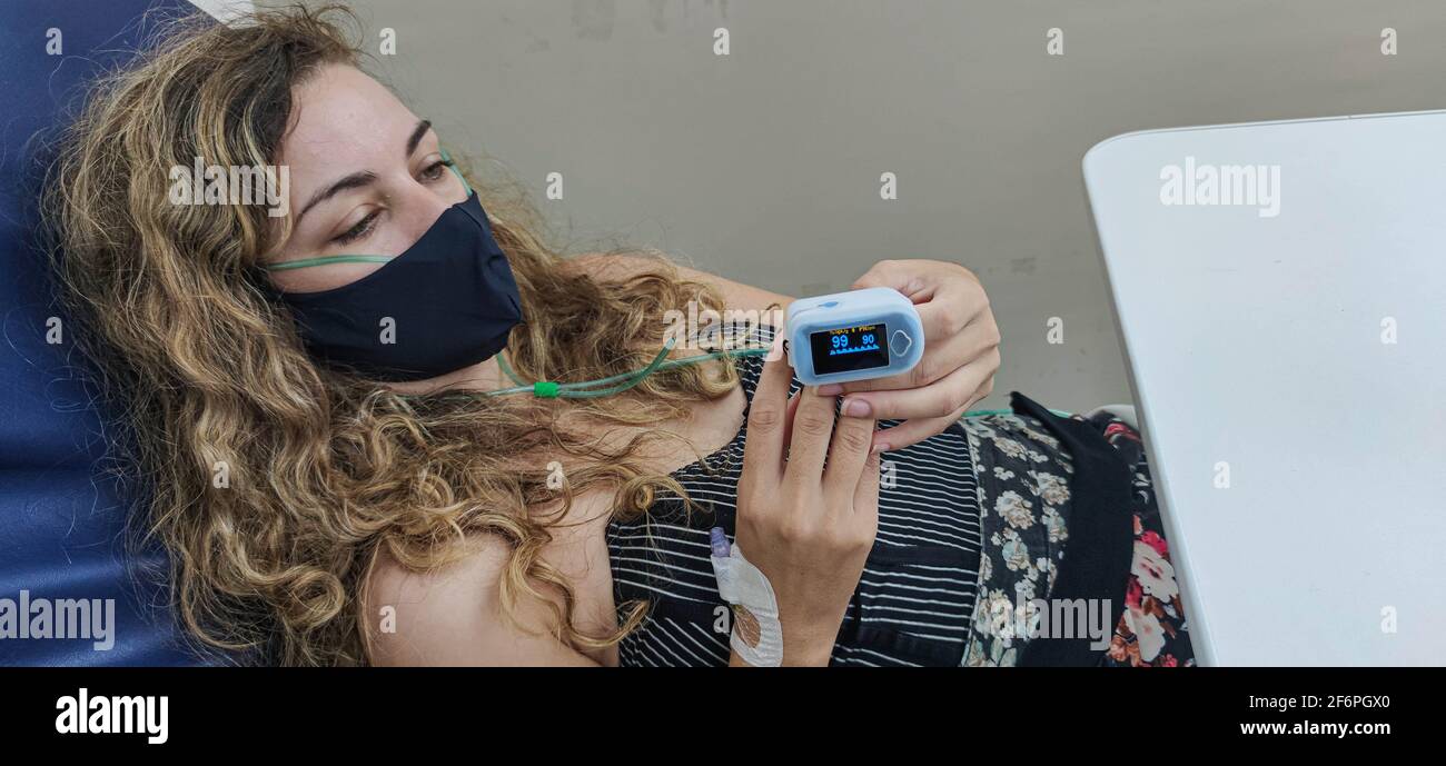 Mujer joven con oxímetro en el dedo recibiendo tratamiento contra Covid-19  en Brasil. Hospital público. Urgencia y emergencia. Tratamiento de un  paciente Fotografía de stock - Alamy