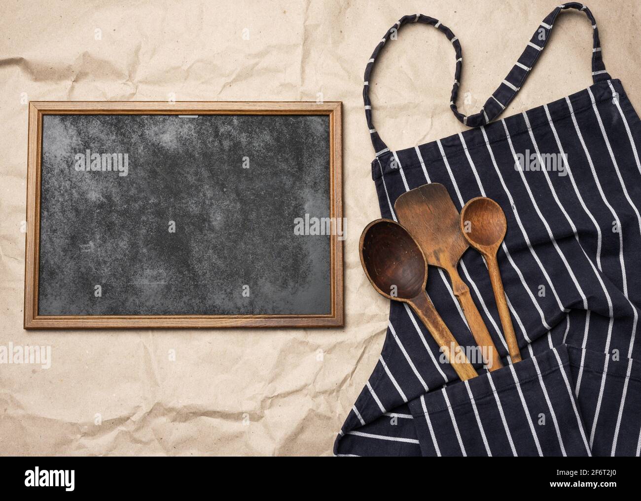 marco de madera cuadrada en blanco y delantal azul chef, vista superior, espacio de copia. Foto de stock