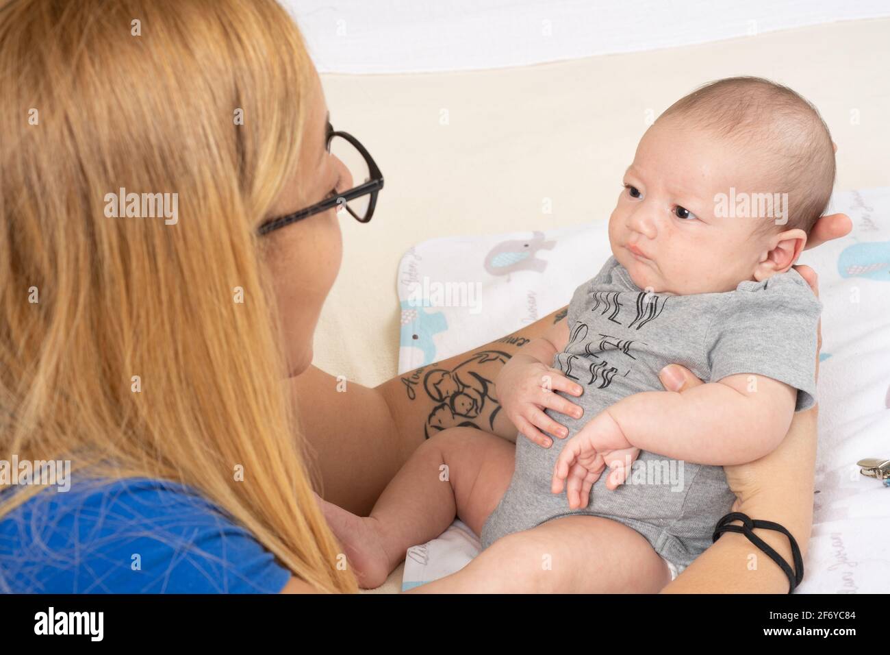 Recién nacido niño de 7 semanas de edad intención de escuchar a la madre mientras habla con él Foto de stock