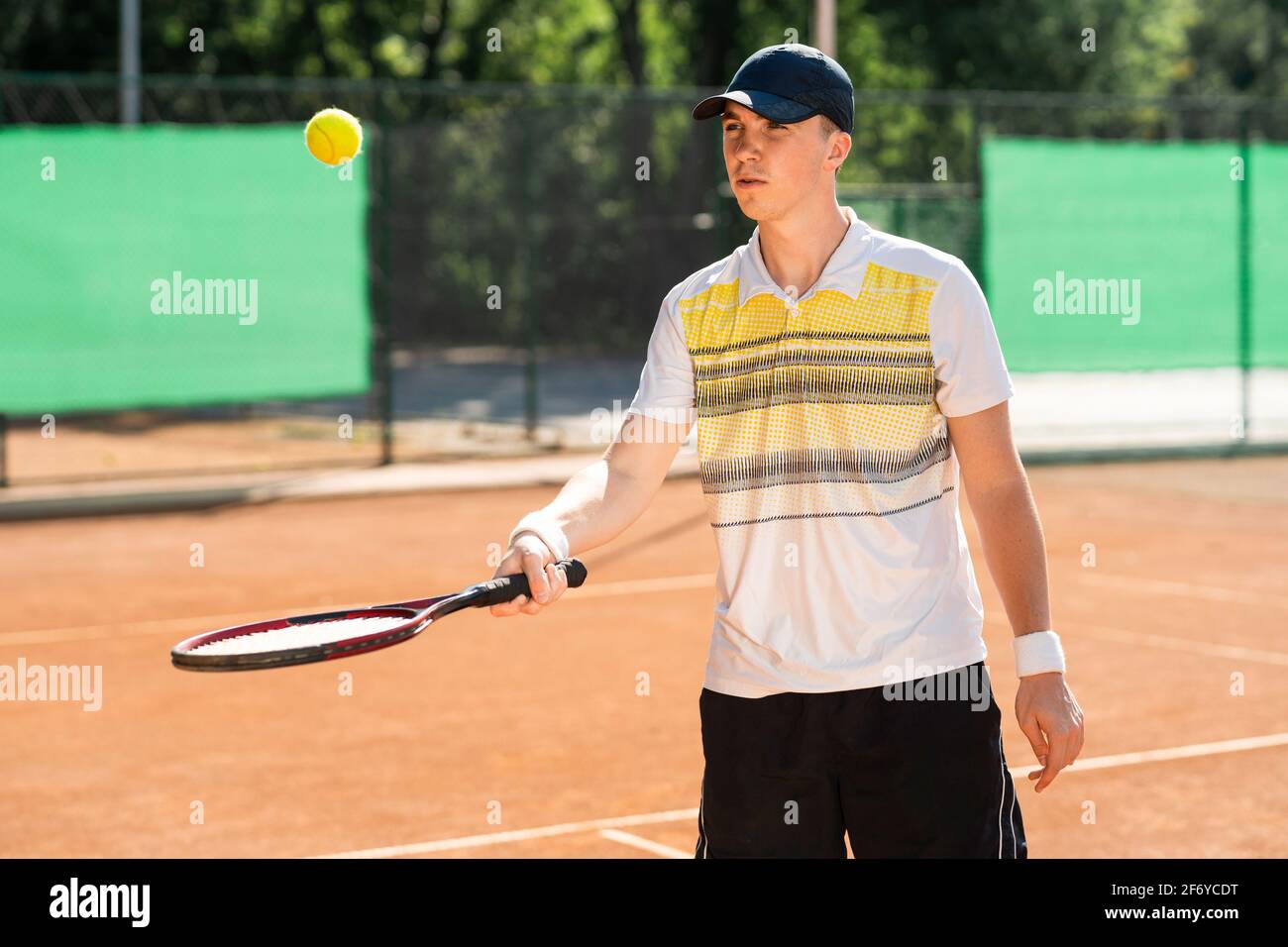 El hombre aprende a jugar al tenis. Jugador de tenis lanzando