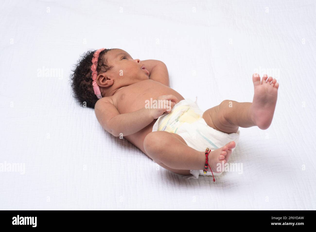 Bebé recién nacido niña de 3 semanas de edad, despierto, alerta, acostado en la espalda, en pañal Foto de stock