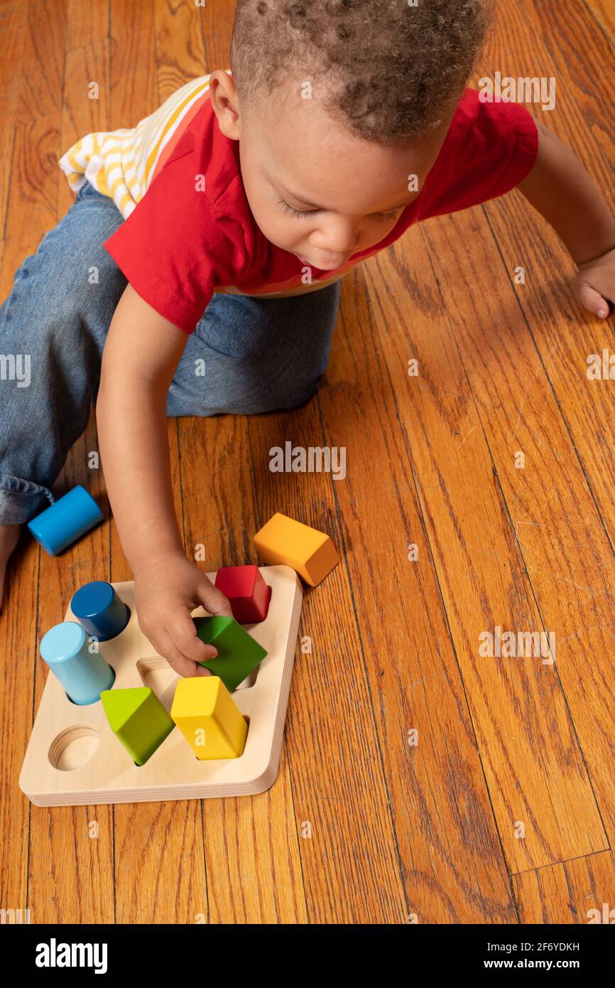 Niño de dos años jugando con sorter de forma geométrica Foto de stock