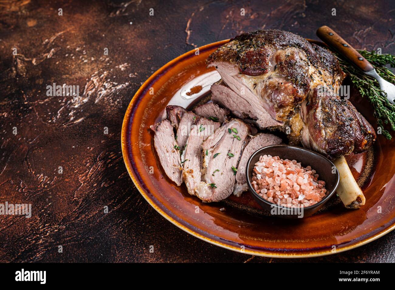 Pierna de cordero asado a la barbacoa cortada en un plato rústico. Fondo  oscuro. Vista superior. Espacio de copia Fotografía de stock - Alamy