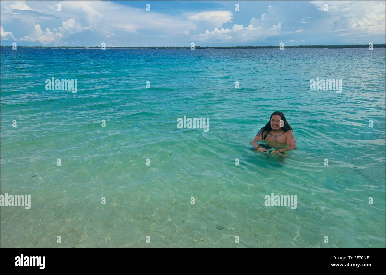 Hombre filipino que se aganta en las aguas poco profundas de color turquesa  de la isla de Sillon (también conocida como "isla virgen"), frente a la  isla de Bantayan, Cebú, Filipinas Fotografía