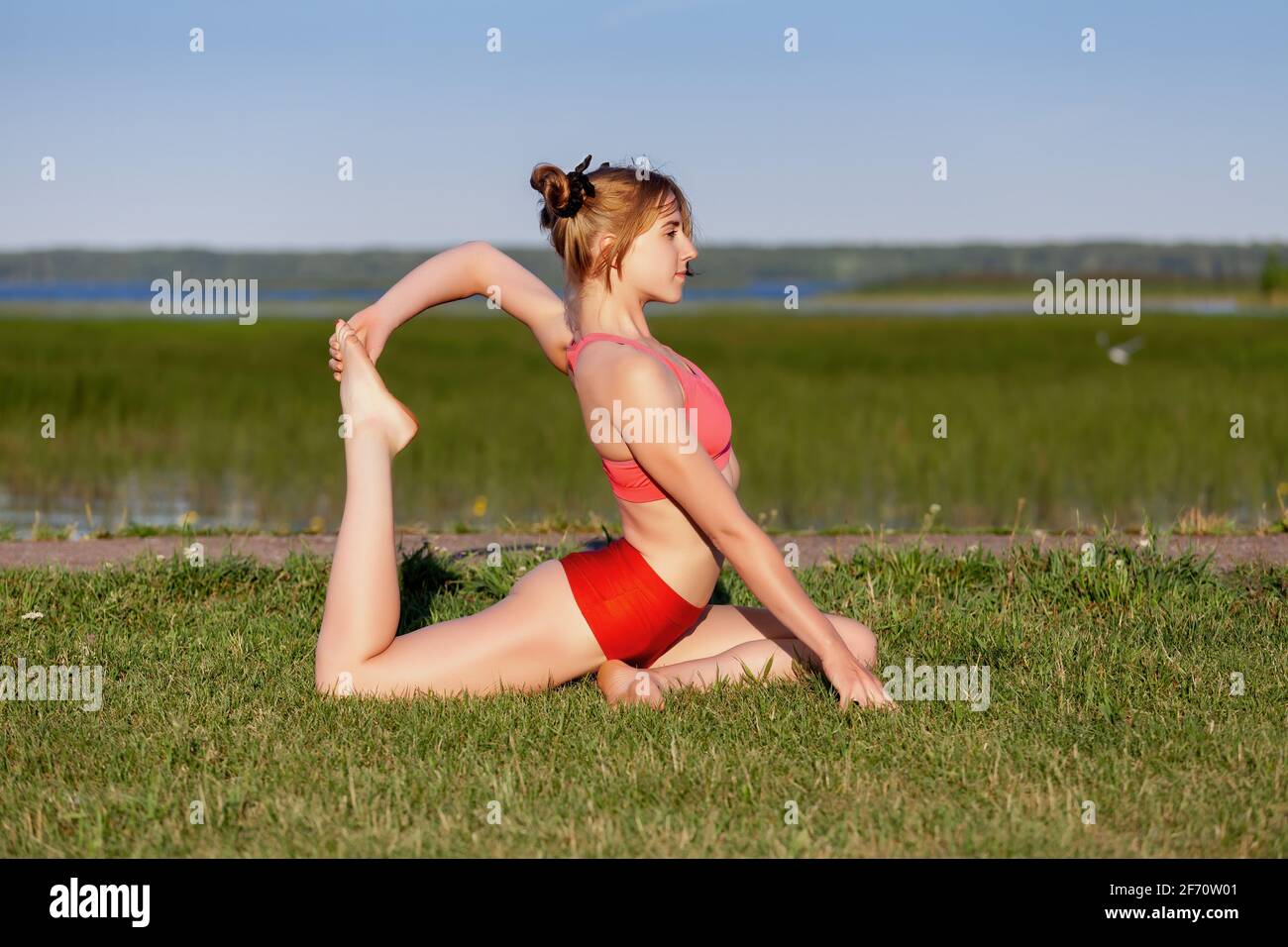 Mujer Caucásica Joven Que Hace Yoga En La Montaña, Vestido Con Ropa  Deportiva Blanca. Ella Relajarse Y Meditar En La Parte Superior De La  Cumbre En La Estera De Yoga. Kazajstán, Almaty