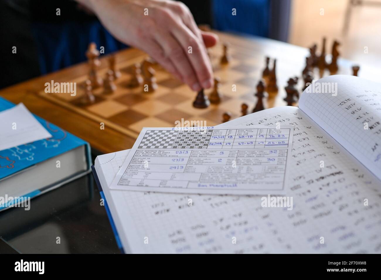 Berlín, Alemania. 01st de abril de 2021. El ajedrecista Heiermann juega al ajedrez  por correspondencia en su apartamento y está rodeado de sus notas y libros  de ajedrez. En primer plano una