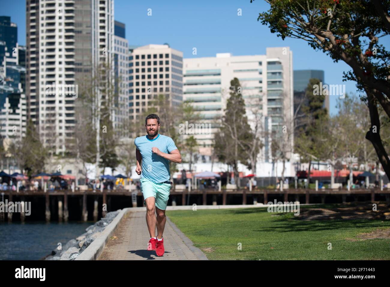 Corredor activo sano jogging al aire libre. Deporte y estilo de vida saludable. Joven atleta corriendo en el parque urbano de la ciudad. Foto de stock