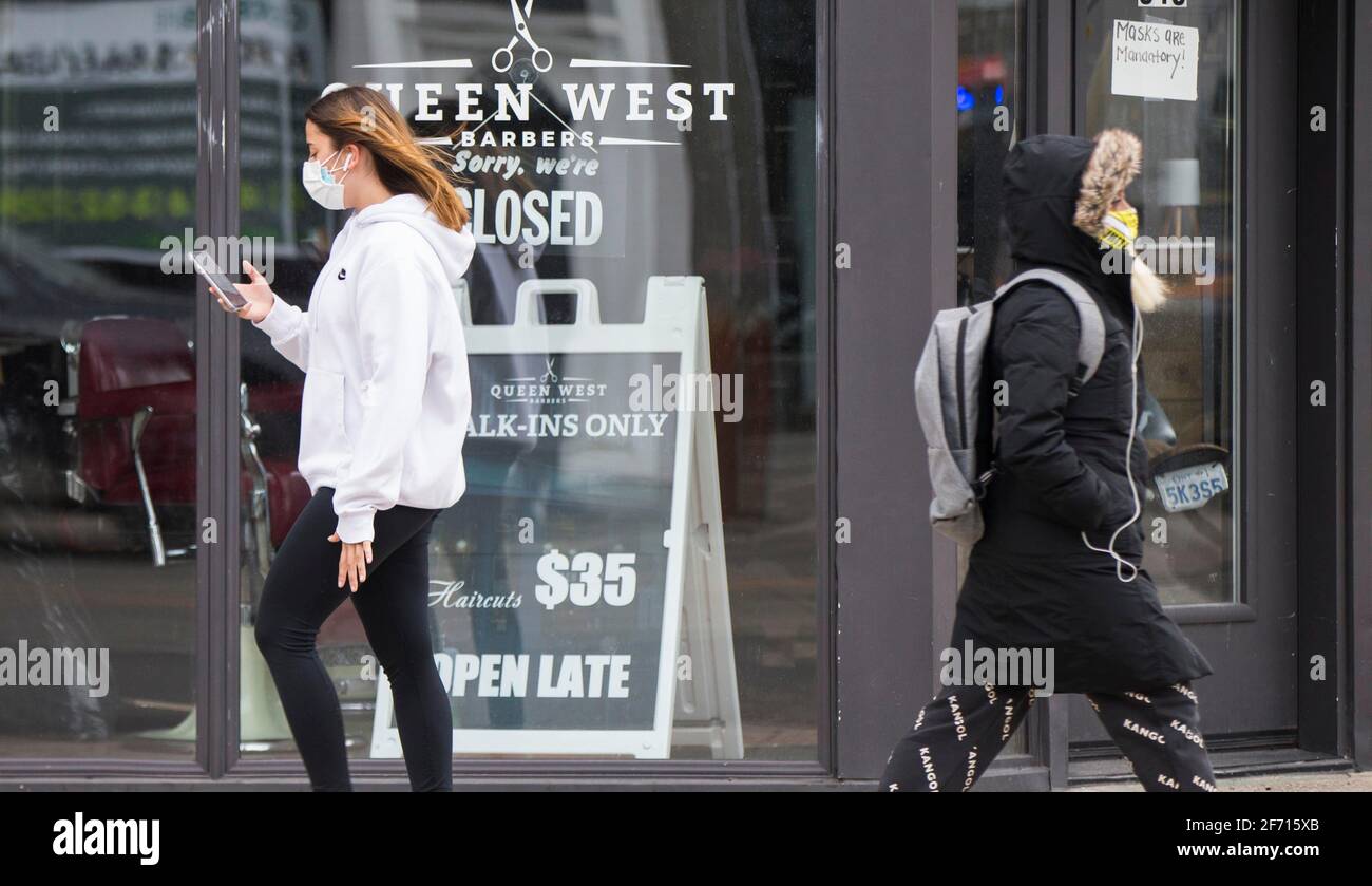 Toronto, Canadá. 3rd de abril de 2021. Las personas que usan máscaras de cara pasan por un salón cerrado de peluquería en Toronto, Canadá, el 3 de abril de 2021. Los casos COVID-19 de Canadá han ascendido a 1.001.645, informó CTV. Canadá se convirtió en el 23rd país del mundo en superar los 1 millones de casos confirmados, según un recuento mundial de infecciones por la Universidad Johns Hopkins. Crédito: Zou Zheng/Xinhua/Alamy Live News Foto de stock