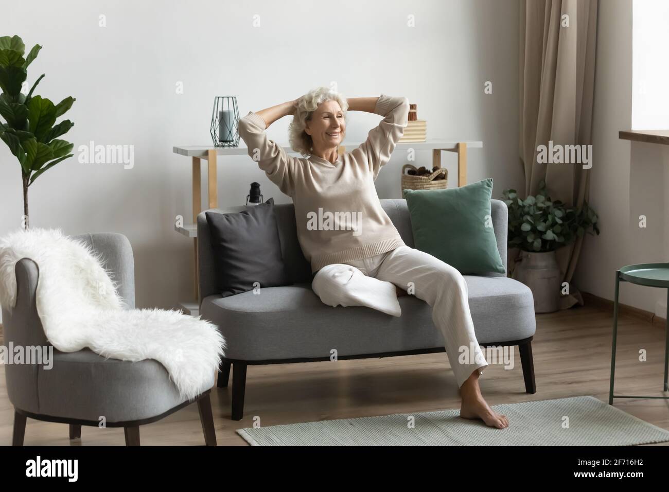 Feliz pensionista de mediana edad de 60s años pasando tiempo libre en casa Foto de stock