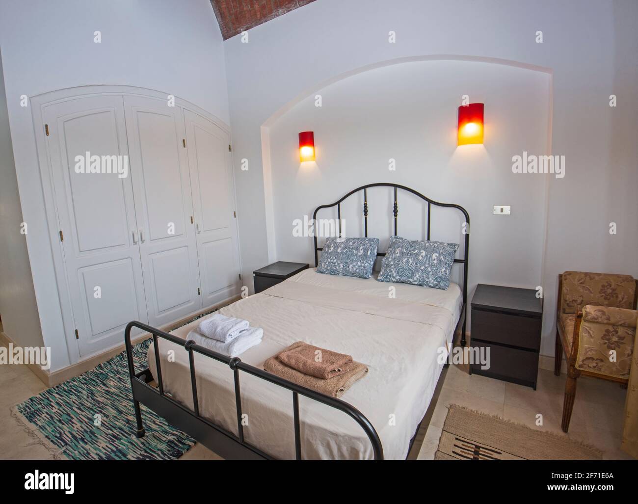 Acogedor dormitorio con cama grande, cojines decorativos y paredes a rayas  en blanco y azul Fotografía de stock - Alamy