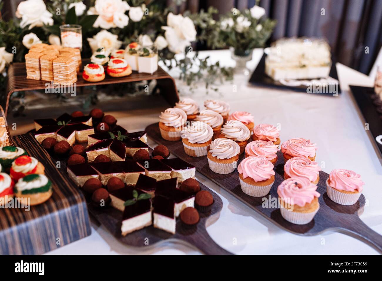 candy bar decorado con un delicioso buffet dulce con cupcakes, eclairs,  dulzura y flores, y otros postres, dulces, Mesa de postre para una boda o  Fotografía de stock - Alamy
