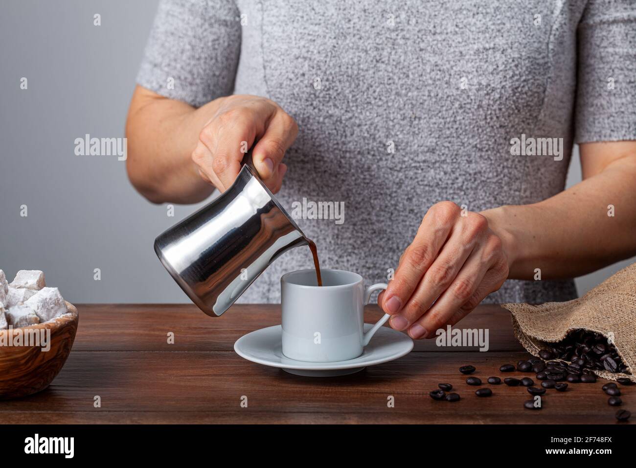 Café turco tradicional servido en tazas clásicas con delicias turcas. Una  cafetera de metal está en el fondo. Una mujer está echando café a la c  Fotografía de stock - Alamy