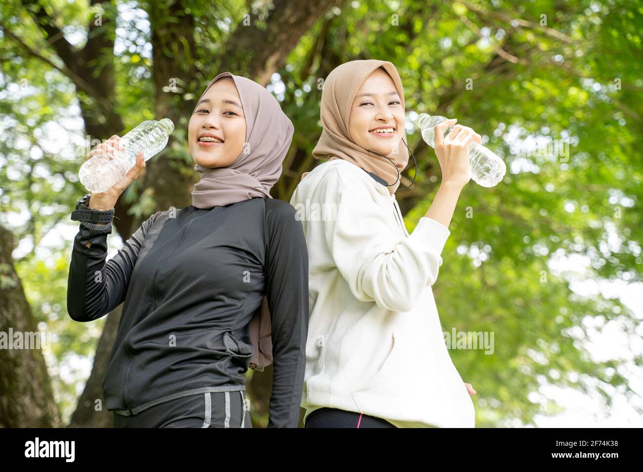 mujer musulmana con bufanda para la cabeza bebiendo una botella de agua  durante el ejercicio al aire libre Fotografía de stock - Alamy