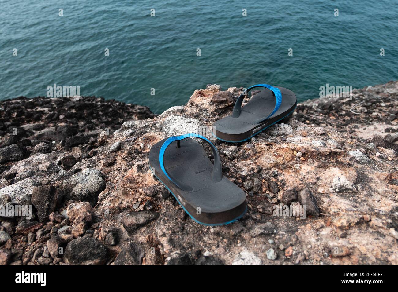Un par de chanclas negras azules o zapatillas o calzado que se mueve por la isla durante las vacaciones Fotografía de stock - Alamy