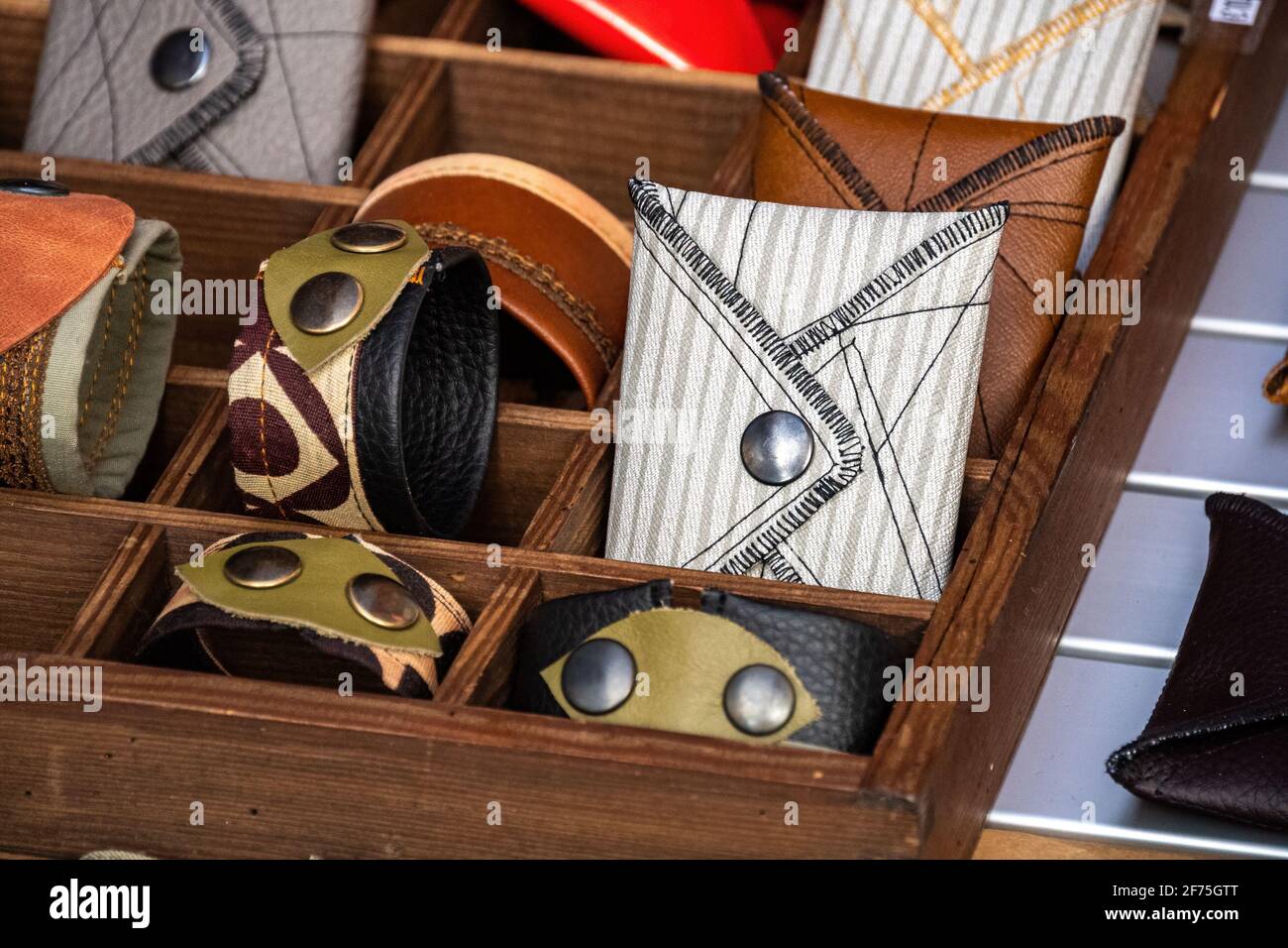 Carteras y pulseras a mano, de cuero y tela, remaches metálicos, en un estante de la tienda. Accesorio moda Fotografía de stock - Alamy