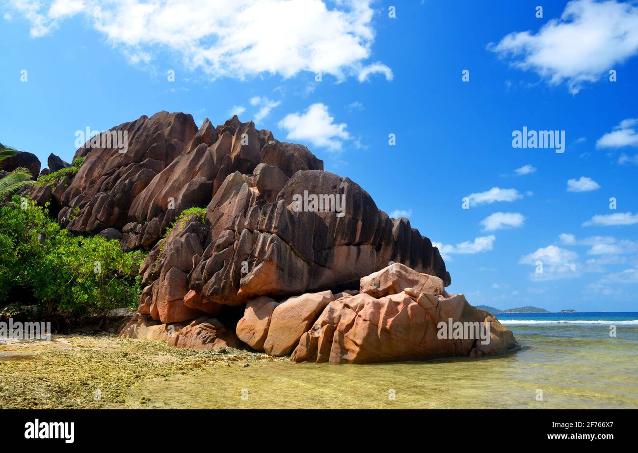 Isla La Digue, océano Índico, Seychelles. Gran roca de granito en la playa de Anse Grosse Roche. Paisaje tropical con mar y cielo azul. Foto de stock